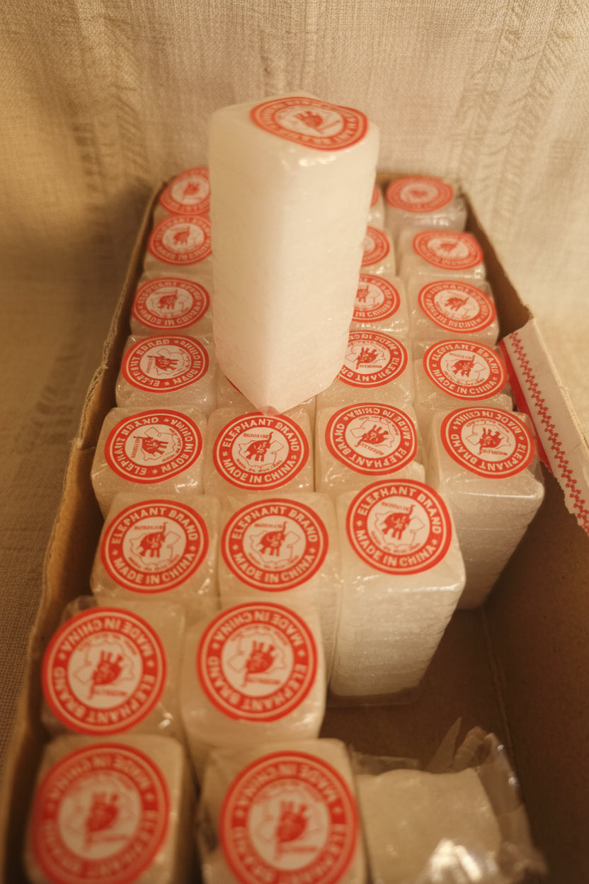 Box of white rolls with red labels on a shelf