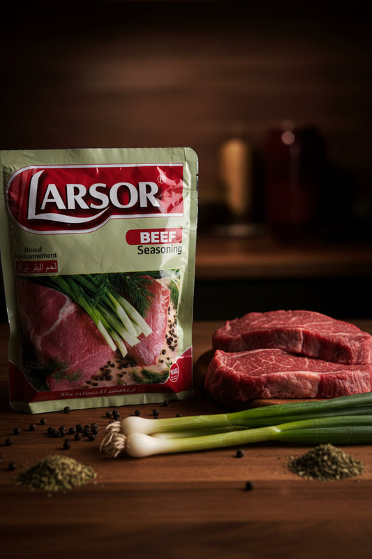 A package of Larsor Beef Seasoning stands on a wooden surface next to two raw beef steaks, green onions, and scattered peppercorns, with a dark, blurred kitchen background.